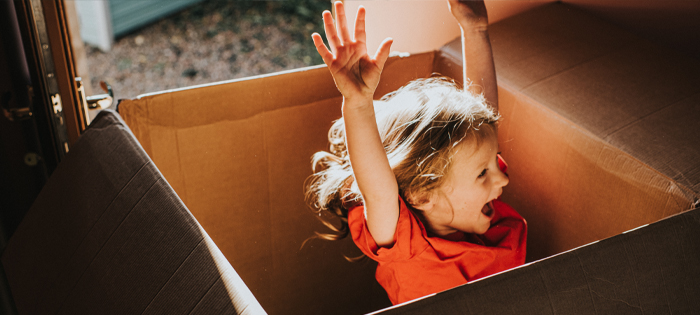 A child playing in a cardboard box